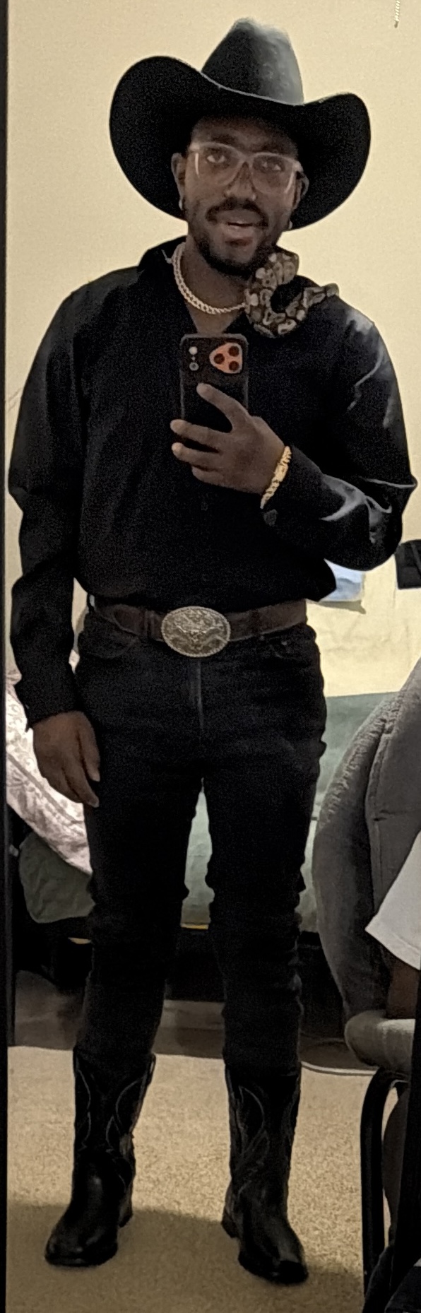 Napoleon B’Myte in a black cowboy hat with a snake resting on his shoulder